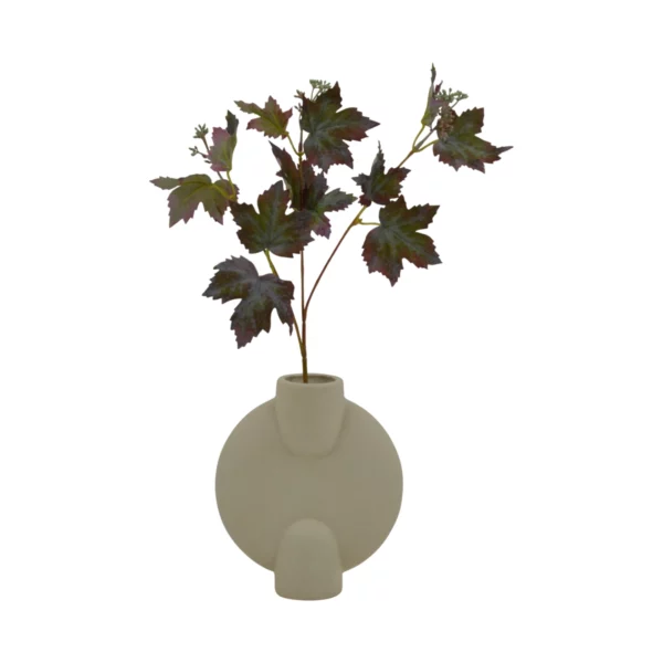 Short maple leaf stems arranged in a round, minimalist beige vase, showcasing autumnal foliage.